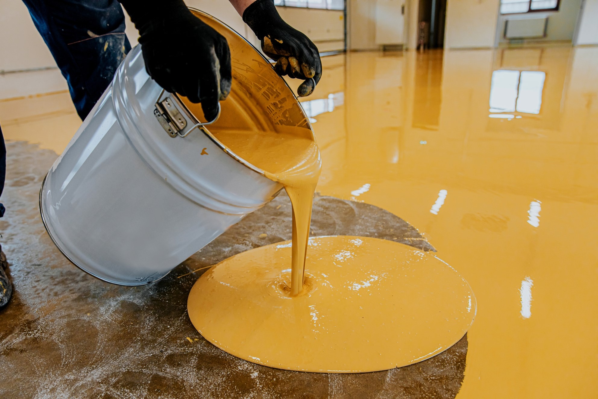 Worker pouring yellow epoxy flooring