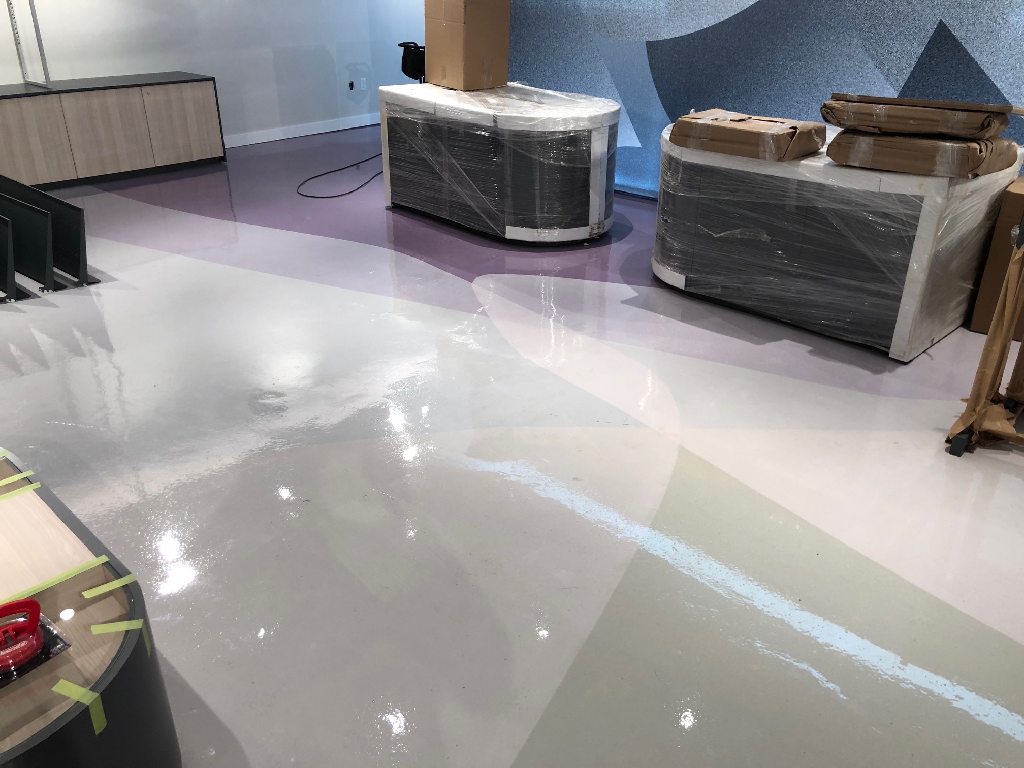 Glossy multi-colour epoxy floor in a commercial interior during installation