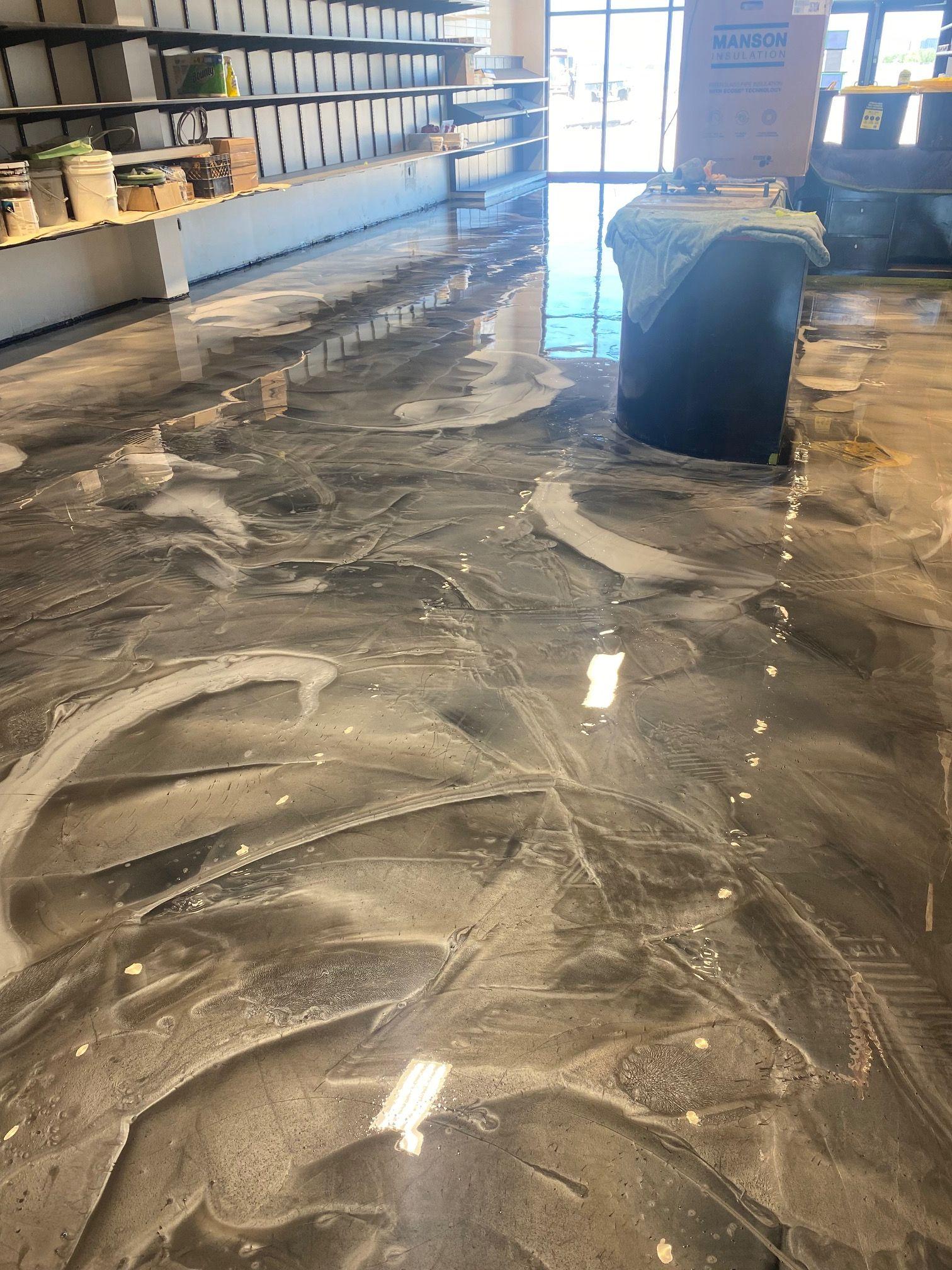 winnipeg-heat-uv-epoxy-floors Sunlight shining across a black-and-white metallic epoxy floor in a commercial space